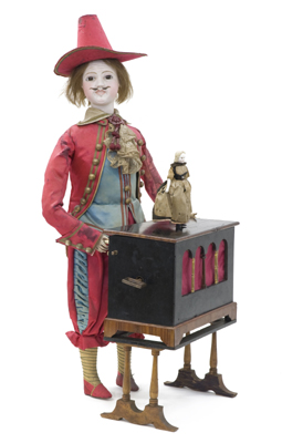 Gustave Vichy : < Le joueur d'orgue de Barbarie > Bel et rare automate en excellent état d'origine. Debout derriere son instrument, cet homme tourne la manivelle tandis qu'une poupée danse au-dessus de l'orgue. Rare tete de caractere en biscuit, mains en tôle laquée, beaux habits en soierie rouge et bleue. Vers 1880.