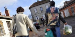 Des personnes sortent des locaux du Secours Populaire avec des colis de nourriture, le 4 décembre 2009 à Saint-Eloy-les-Mines (AFP)